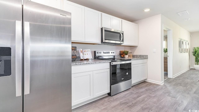 kitchen featuring stainless steel appliances, white cabinetry, and light hardwood / wood-style flooring