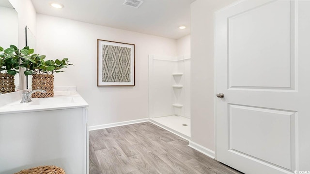 bathroom featuring vanity, hardwood / wood-style flooring, and walk in shower