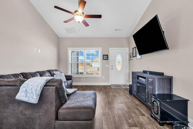 living room with dark wood-type flooring, vaulted ceiling, and ceiling fan