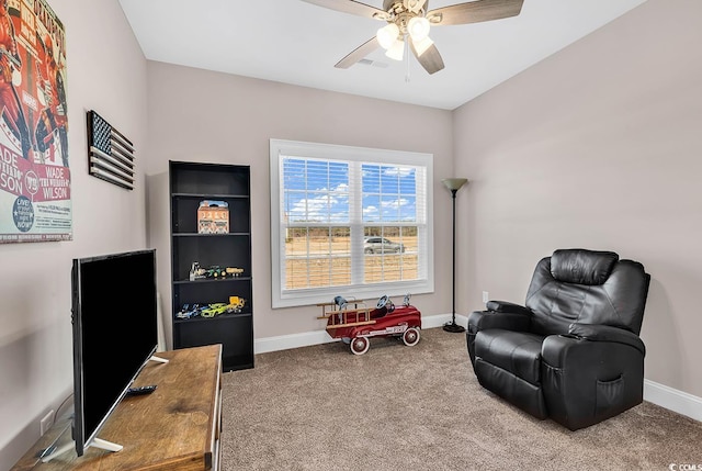 living area with carpet and ceiling fan