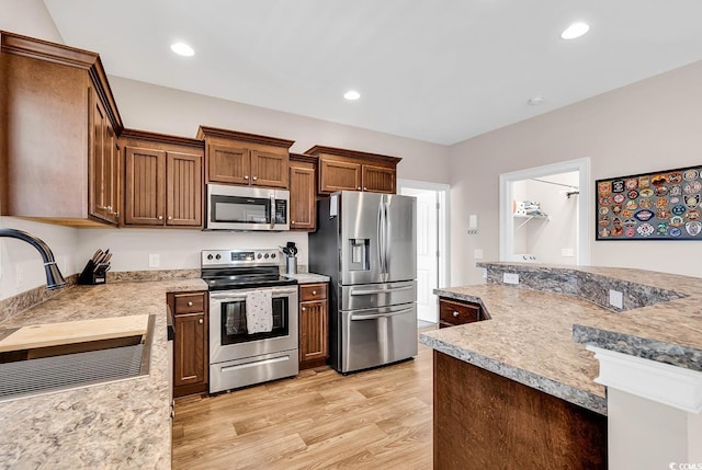 kitchen featuring appliances with stainless steel finishes, light hardwood / wood-style floors, and sink