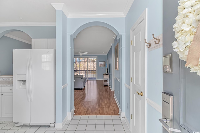 hall featuring light tile patterned floors and ornamental molding