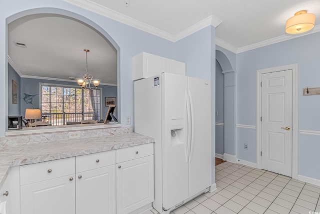 kitchen featuring light tile patterned flooring, white cabinetry, an inviting chandelier, ornamental molding, and white refrigerator with ice dispenser