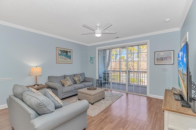 living room with crown molding, ceiling fan, a textured ceiling, and light wood-type flooring