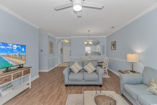 living room with crown molding, a textured ceiling, and light hardwood / wood-style flooring