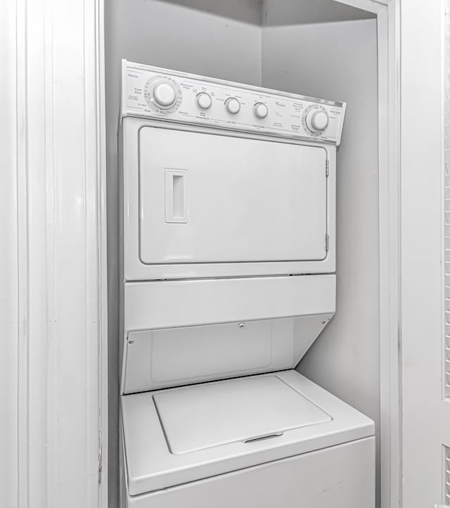 laundry room with stacked washing maching and dryer