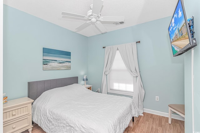 bedroom with ceiling fan and light hardwood / wood-style floors