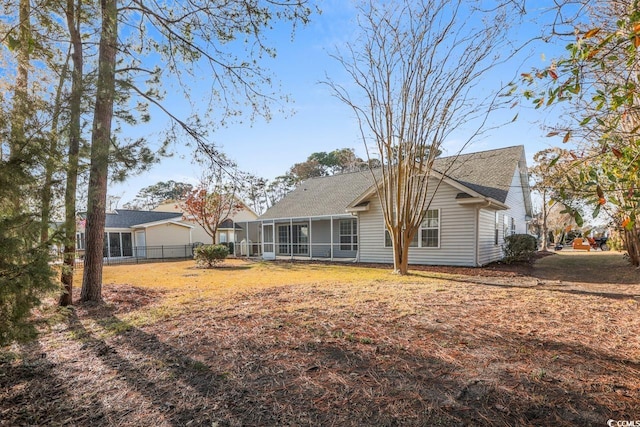 back of house with a sunroom and a yard