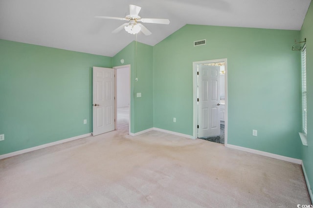 unfurnished bedroom with lofted ceiling, connected bathroom, light carpet, and ceiling fan