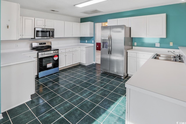 kitchen featuring white cabinetry, sink, and appliances with stainless steel finishes