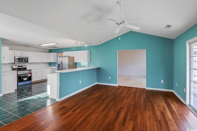 kitchen featuring white cabinetry, dark wood-type flooring, kitchen peninsula, and appliances with stainless steel finishes