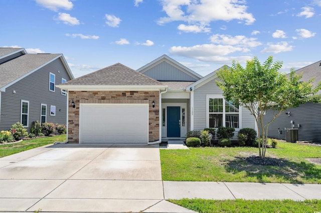 view of front of house featuring cooling unit, a garage, and a front lawn