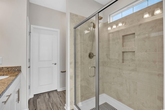 bathroom featuring vanity, an enclosed shower, and wood-type flooring