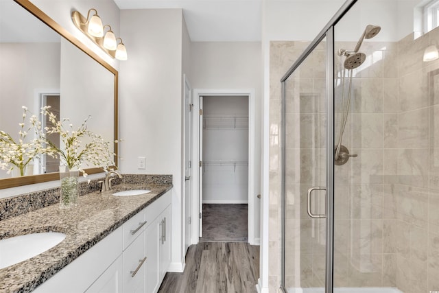 bathroom with hardwood / wood-style flooring, vanity, and walk in shower