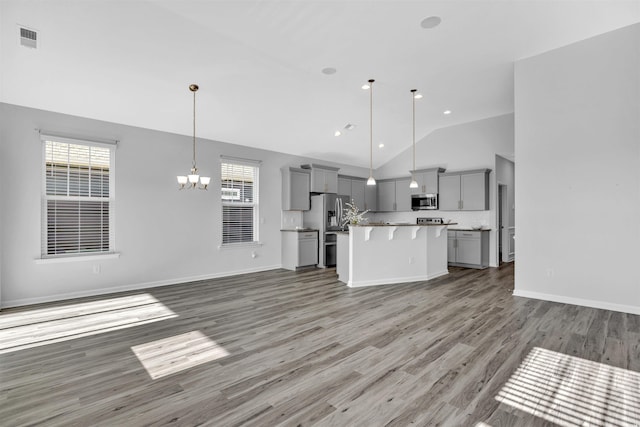 kitchen with gray cabinets, appliances with stainless steel finishes, hanging light fixtures, a center island, and a chandelier