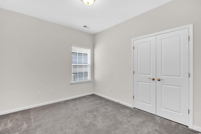 unfurnished bedroom featuring light colored carpet and a closet