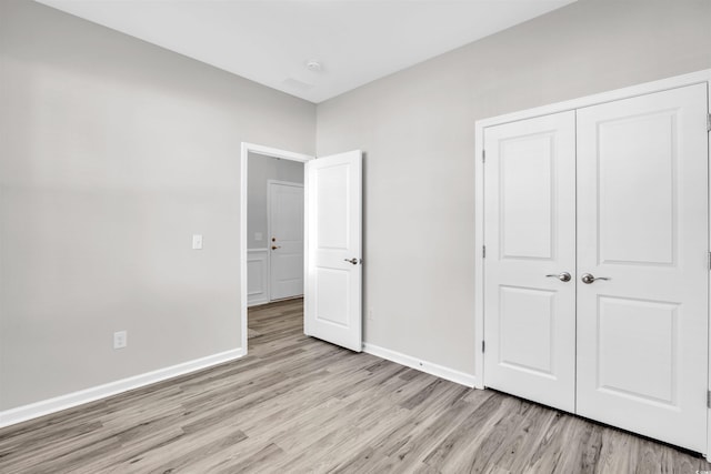 unfurnished bedroom with a closet and light hardwood / wood-style flooring