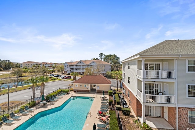 pool with a residential view, a patio, and fence