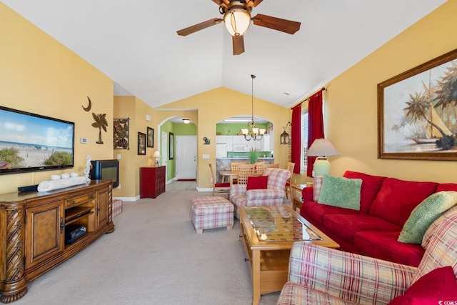 carpeted living area featuring baseboards, arched walkways, ceiling fan with notable chandelier, and vaulted ceiling