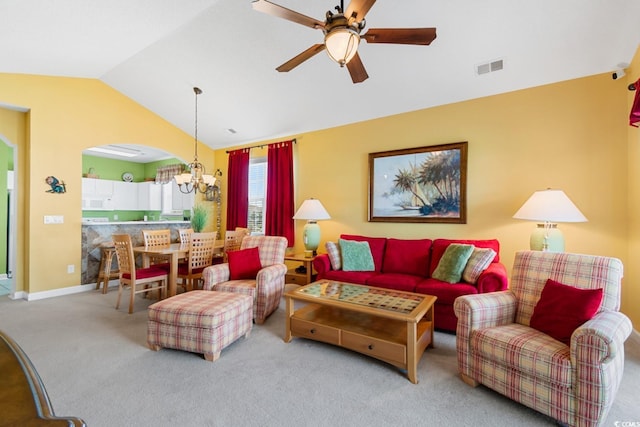 carpeted living area with visible vents, ceiling fan with notable chandelier, baseboards, arched walkways, and lofted ceiling