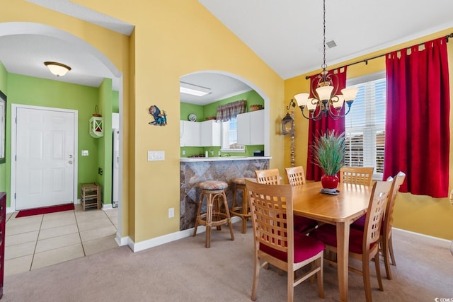 carpeted dining room with tile patterned flooring, visible vents, lofted ceiling, arched walkways, and a notable chandelier