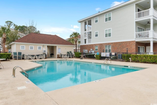 pool with a patio area and fence