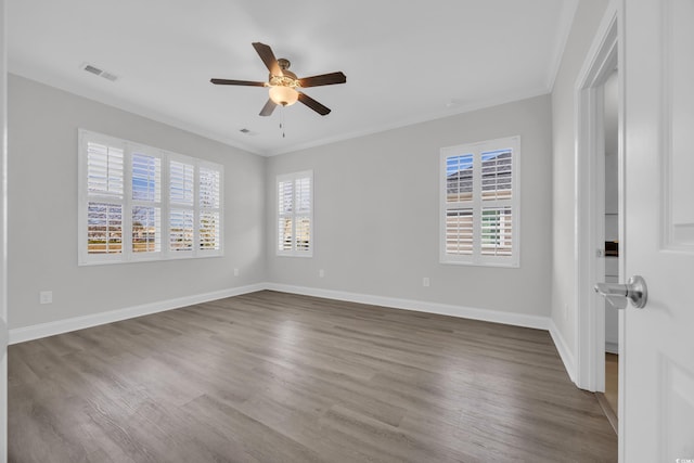 empty room with a wealth of natural light, ceiling fan, hardwood / wood-style flooring, and ornamental molding