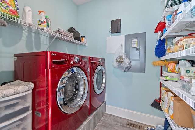 laundry room with separate washer and dryer, hardwood / wood-style floors, and electric panel