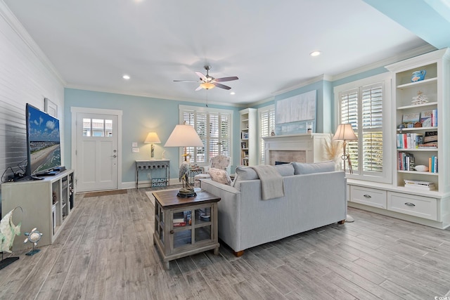 living room with crown molding, light hardwood / wood-style floors, and a healthy amount of sunlight