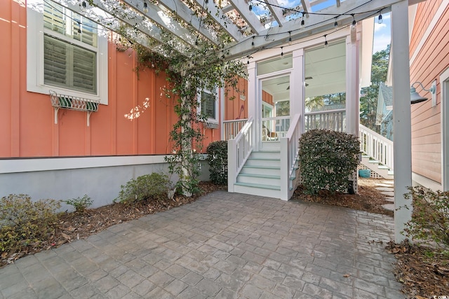 view of exterior entry featuring a pergola and a patio