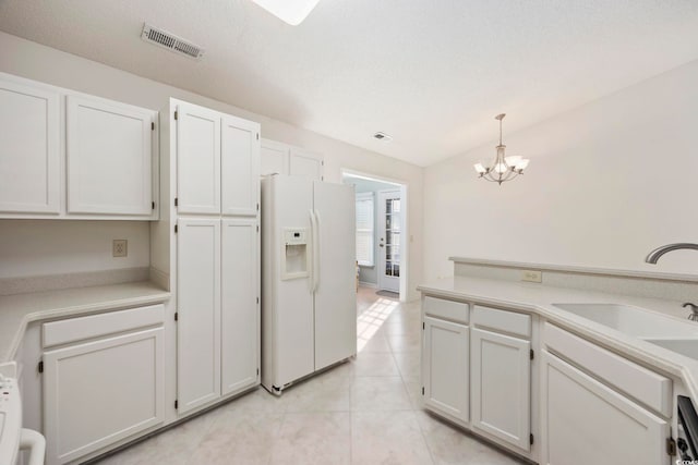 kitchen with sink, white cabinets, hanging light fixtures, white fridge with ice dispenser, and light tile patterned floors