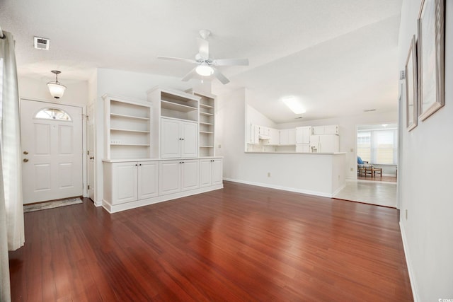 unfurnished living room featuring dark wood-type flooring, ceiling fan, and lofted ceiling