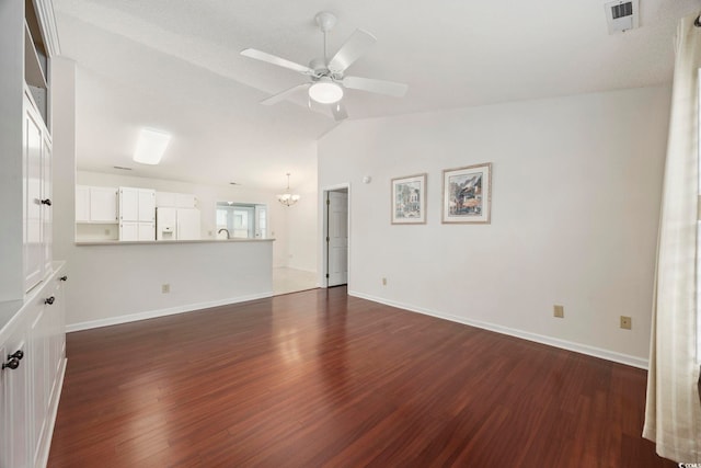 unfurnished living room featuring lofted ceiling, ceiling fan with notable chandelier, and dark wood-type flooring