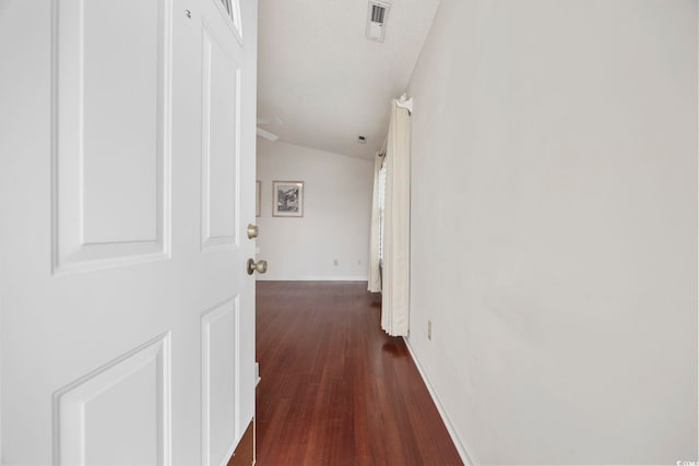 hallway featuring dark hardwood / wood-style flooring and vaulted ceiling