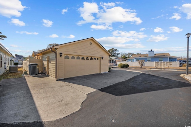 exterior space with central AC and a garage