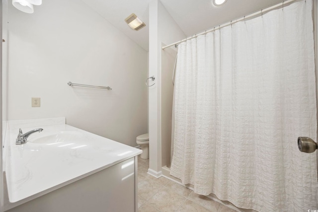 bathroom with tile patterned flooring, vanity, and toilet