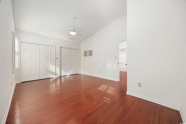 unfurnished bedroom with multiple closets, ceiling fan, high vaulted ceiling, and hardwood / wood-style floors