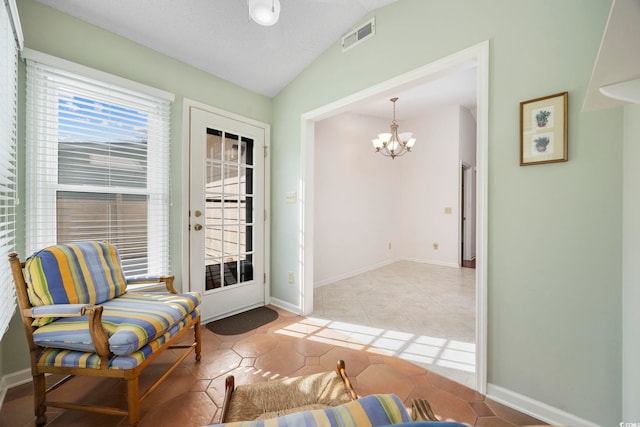 sitting room with vaulted ceiling, tile patterned floors, and a chandelier