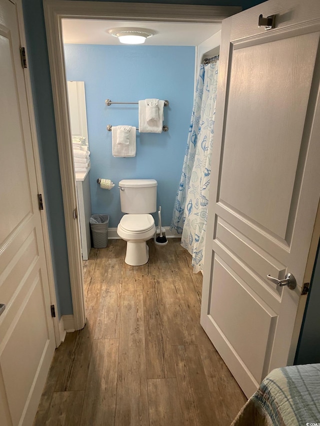 bathroom featuring hardwood / wood-style flooring and toilet