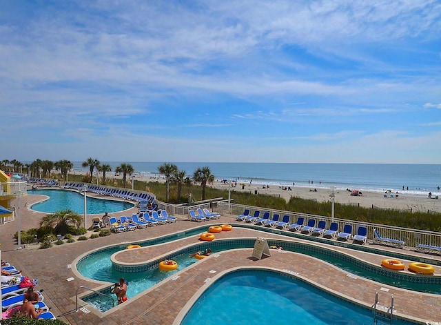 view of pool with a view of the beach and a water view