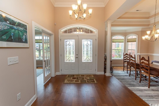 foyer with ornamental molding, dark wood-type flooring, a chandelier, and french doors