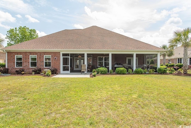 back of house featuring a sunroom and a lawn