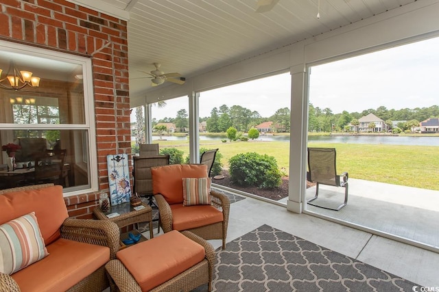 sunroom featuring a water view, plenty of natural light, and ceiling fan with notable chandelier