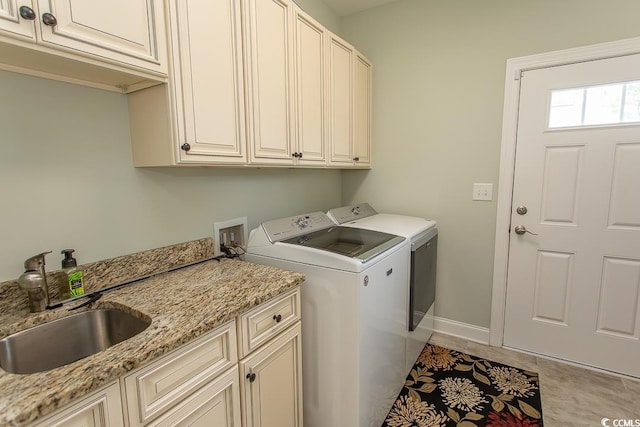 washroom featuring cabinets, washer and dryer, sink, and light tile patterned floors