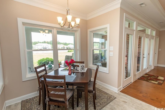 dining space featuring ornamental molding, a healthy amount of sunlight, a chandelier, and light hardwood / wood-style flooring