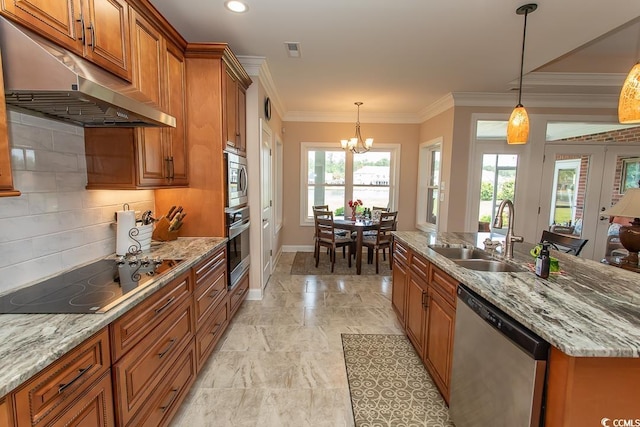 kitchen featuring sink, appliances with stainless steel finishes, pendant lighting, light stone countertops, and a kitchen island with sink