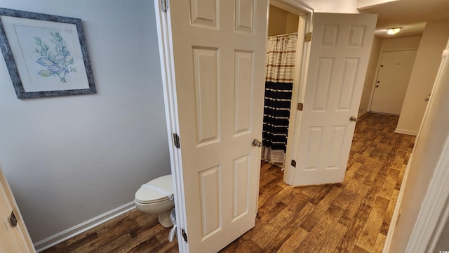 bathroom with wood-type flooring and toilet