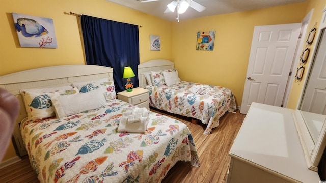 bedroom with ceiling fan and wood-type flooring