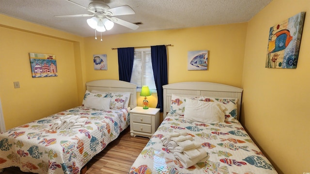 bedroom featuring ceiling fan, a textured ceiling, and light wood-type flooring