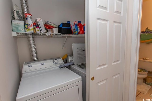 laundry area with separate washer and dryer and tile patterned flooring